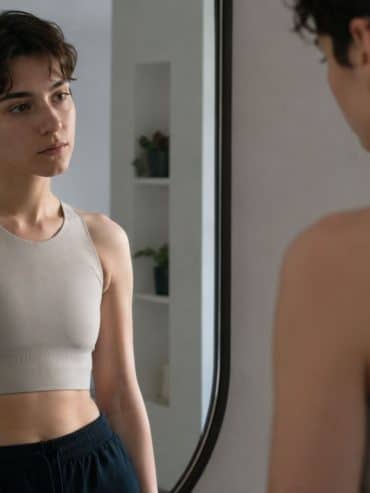 una ragazza mascolina si guarda allo specchio